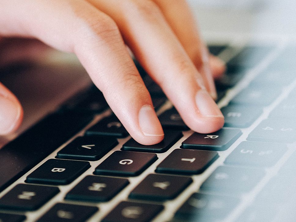 Nahaufnahme männliche Hand auf einer Laptop Tastatur